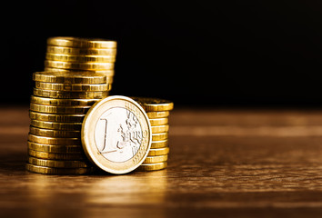 one euro coin and gold money on the desk