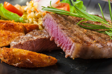 Portion of beef steak served with roast potatoes
