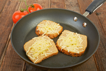 Photo of a grilled cheese sandwich cooking in a large frying pan