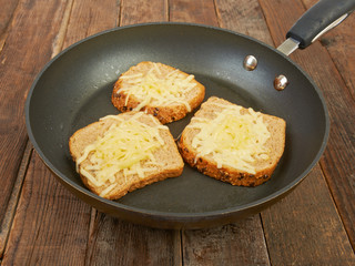 Photo of a grilled cheese sandwich cooking in a large frying pan
