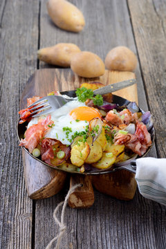 Holzfällermahlzeit mit Bratkartoffeln, Speck und Spiegelei