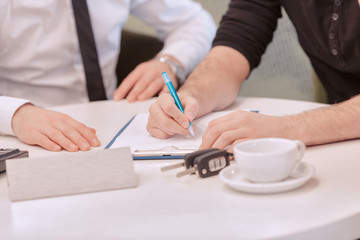 Close up of a male customer signing the contract