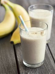 Healthy banana smoothie on wooden background