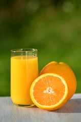 szklanka smacznego soku pomarańczowego i pomarańcze na stole
