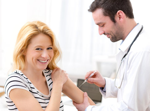 Young attractive woman being vaccinated