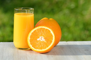 szklanka smacznego soku pomarańczowego i pomarańcze na stole - obrazy, fototapety, plakaty