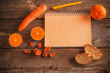 Orange fruits and vegetables on wooden background