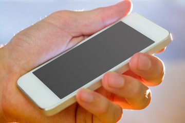 Hand holding a white smartphone