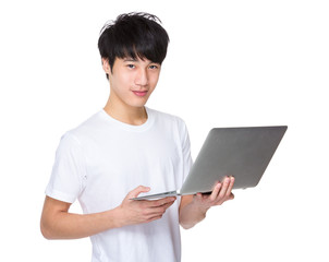 Young asian man holding laptop computer and work