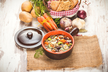 Rural vegetarian broth soup with colorful vegetables and rustic