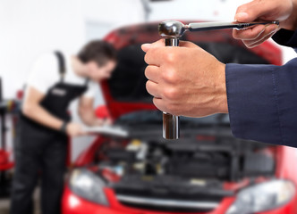 Hand of car mechanic with wrench.