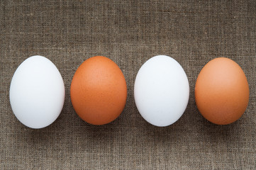 Different color eggs in line on hessian linen fabric cloth