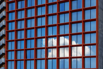 Vetrate di un grattacielo in cui si specchia una nuvoletta