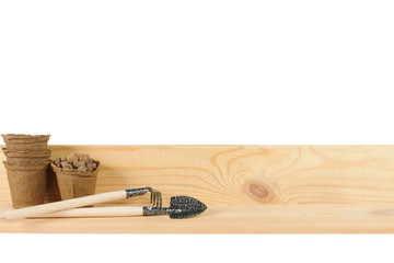 Small garden tools beside peat pots