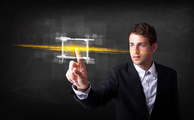 Tech business person touching button with orange light beams con