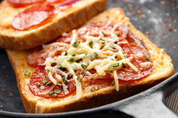 Hot sandwiches with pepperoni frying pan closeup - obrazy, fototapety, plakaty