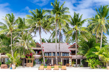 Luxury villa and palm trees at beautiful white sandy beach