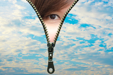 Woman's eyes looking  out of zip opened though the sky