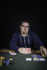 A man playing poker sitting at a table