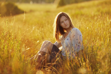 Beautiful woman sitting in a meadow