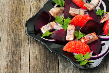 dish with a salad of herring, beetroot and grapefruit - obrazy, fototapety, plakaty