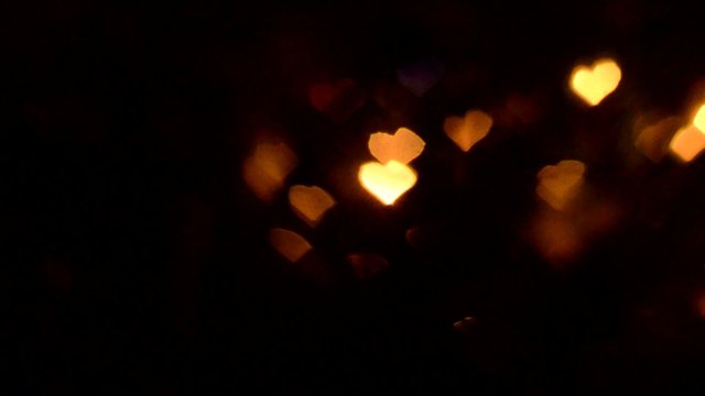blurry colorful lights in heart shape, black background video
