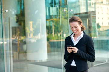 Happy business woman reading text message on mobile phone