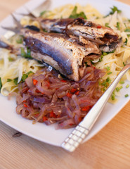 Fish and pasta on white plate