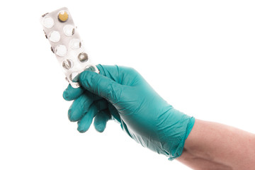 Hand with glove hold a strip of pills up