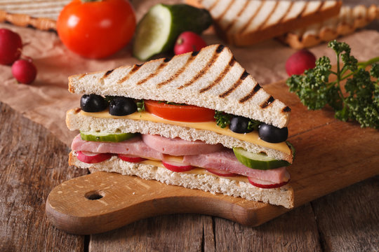 Sandwich with ham, vegetables on the board horizontal