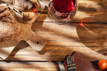 Top view of wine and bread on served wooden table