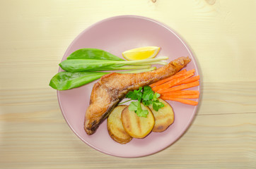 Grilled carp at dish on wooden background