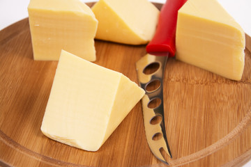 Sliced cheese on the board in the kitchen