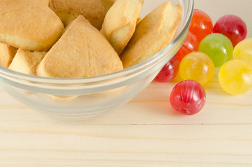 Colorful candies and cookies on wooden background