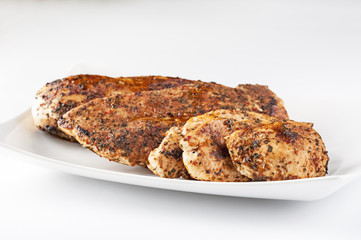 Grilled chicken breast on white plate