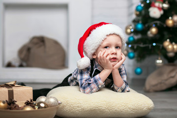Obraz na płótnie Canvas Little boy in Christmas decorations expect a miracle