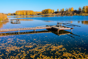 beautiful fall reflections in a lake with a fishing dock