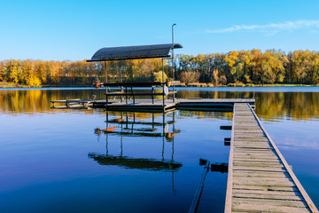 Fototapeta na wymiar beautiful fall reflections in a lake with a fishing dock