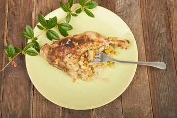 Grilled chicken on the grill on a plate on a wooden table