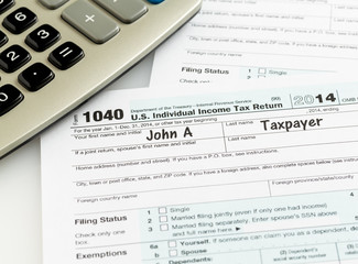 Pen and calculator on 2014 form 1040