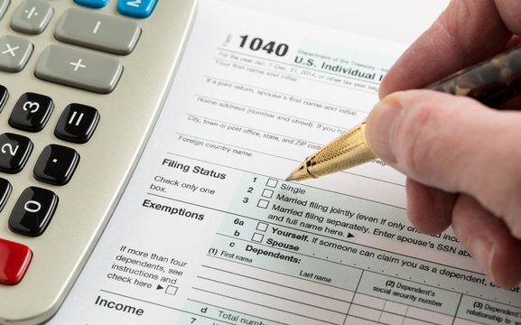 Pen and calculator on 2014 form 1040