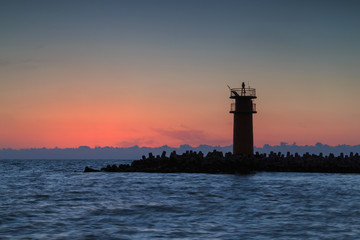 Fototapeta premium Beautiful seascape with lighthouse at sunrise