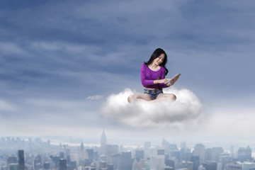 Fototapeta na wymiar Female teenage with tablet on the cloud