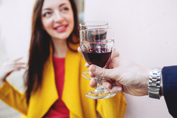 Woman clinking red wine glass with man outdoors