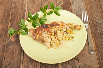 Grilled chicken on the grill on a plate on a wooden table