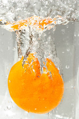 Fototapeta na wymiar Tangerine dropped into water