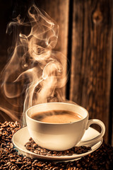 Obrazy na Szkle  Aromatyczna filiżanka kawy z prażonymi nasionami
