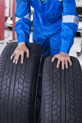 Fototapeta premium Two tires with mechanic in workshop