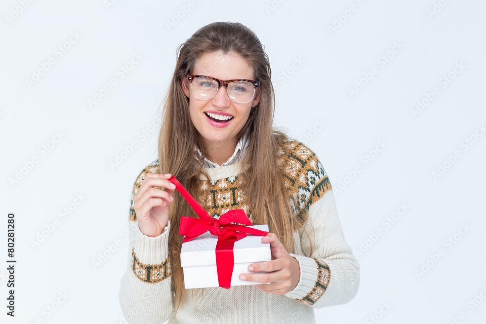 Poster happy geeky hipster smiling at camera and holding present