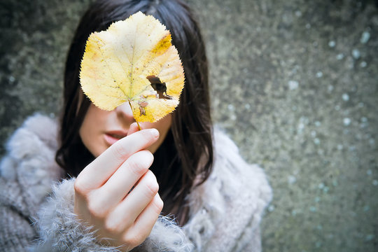portrait of girl who holds a leaf in a hand